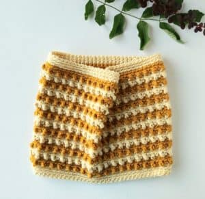 crochet neck warmer cowl in gold and cream on a white background