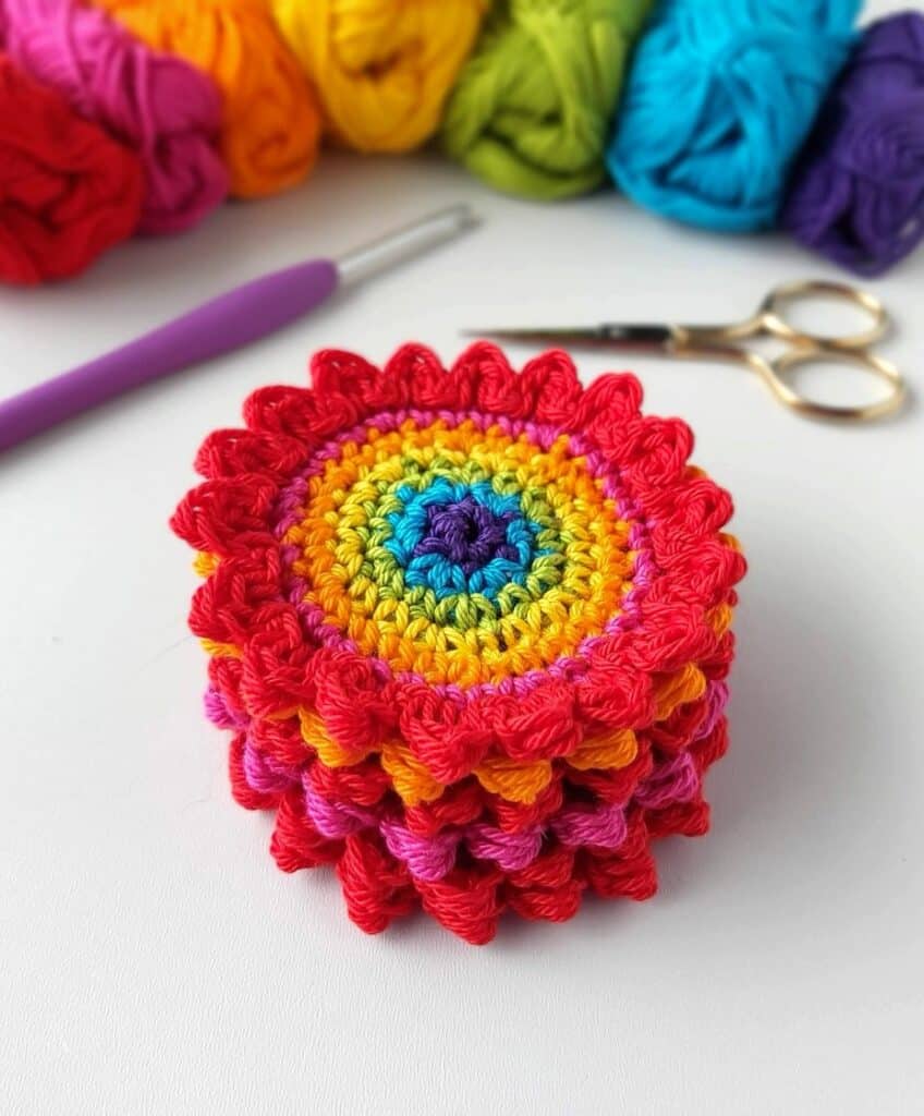 a stack of rainbow crochet flowers