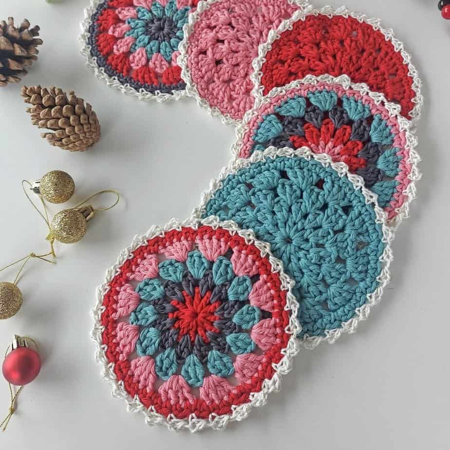 holiday crochet coasters on a white table