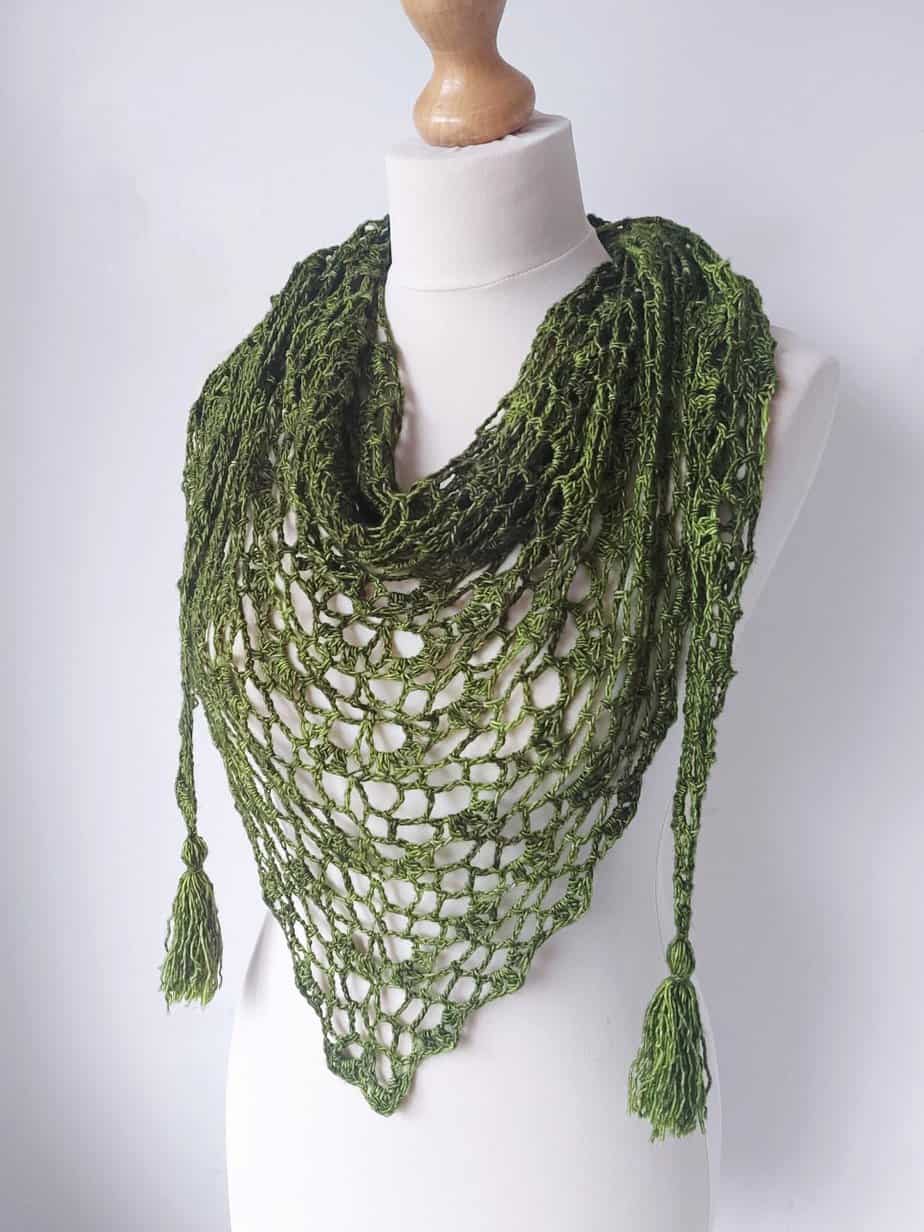 green olive triangle shawl on a mannequin