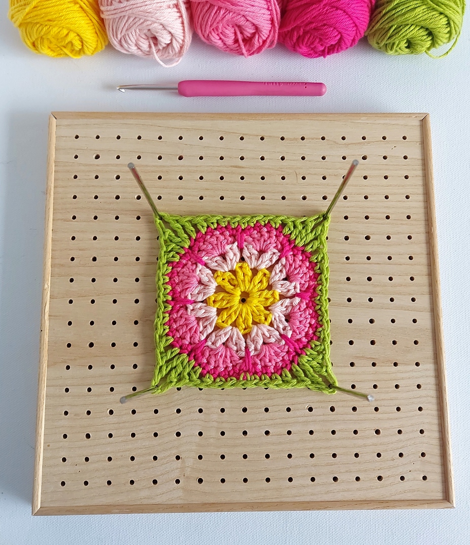 crochet square on a blocking board