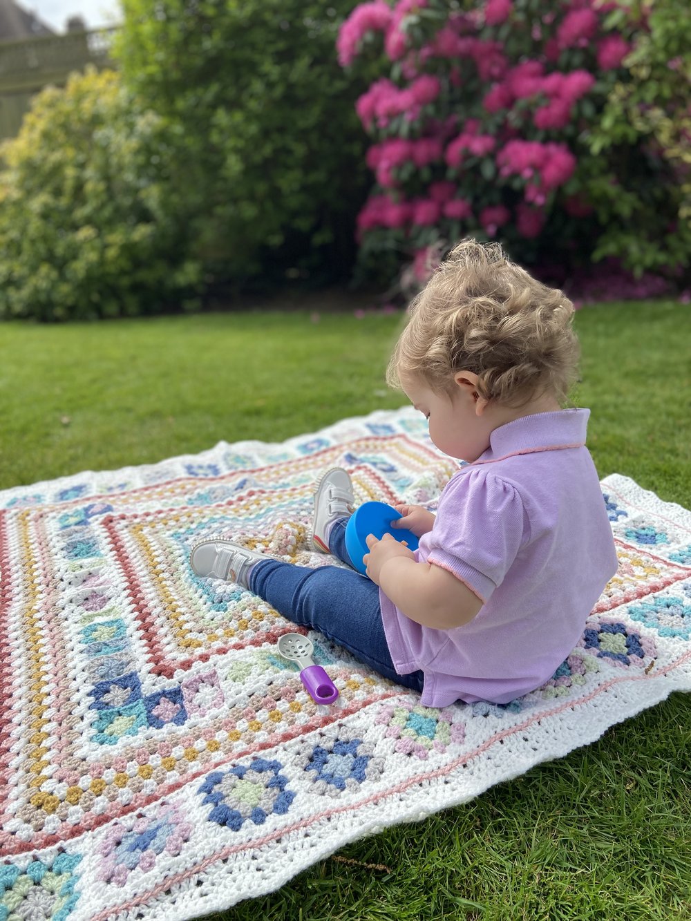 little girl on a crochet granny blanket