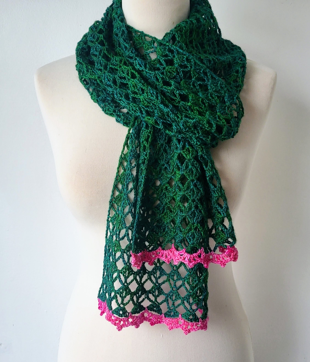 green lace scarf tied at the neck with a hot pink edging