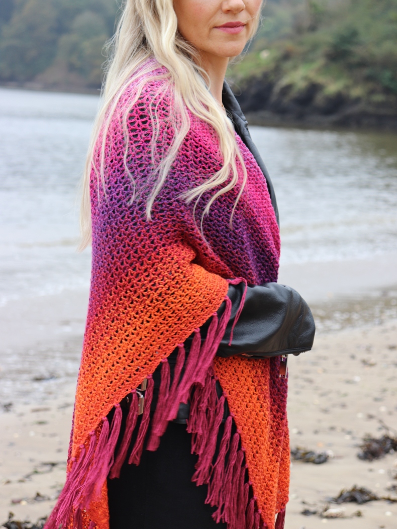 woman on a beach wrapped in a crochet shawl