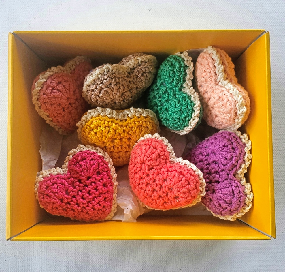 a yellow box filled with crochet hearts