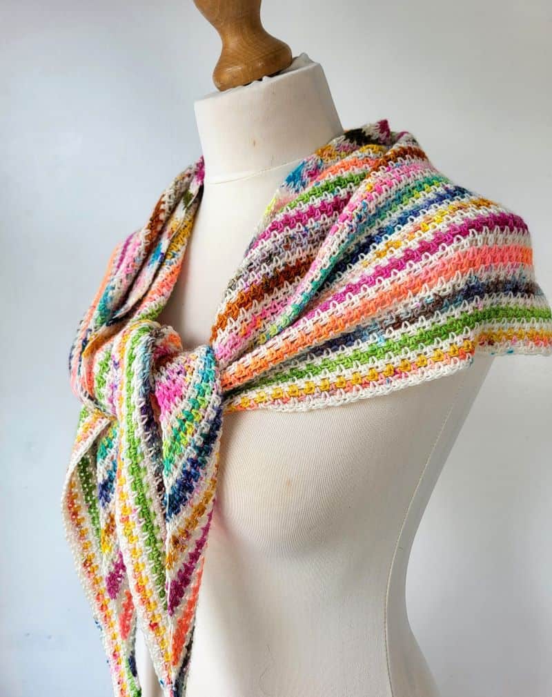 crochet stripe triangle shawl tied at the front on a mannequin