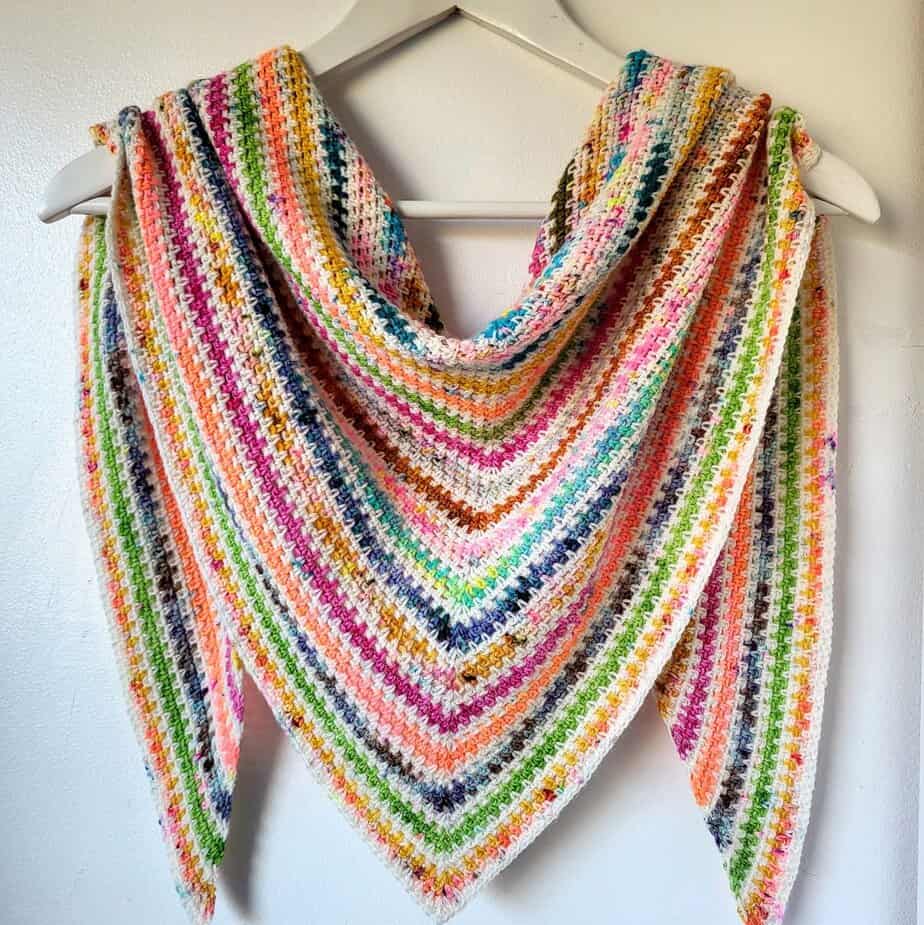 crochet stripe shawl draped on a hanger