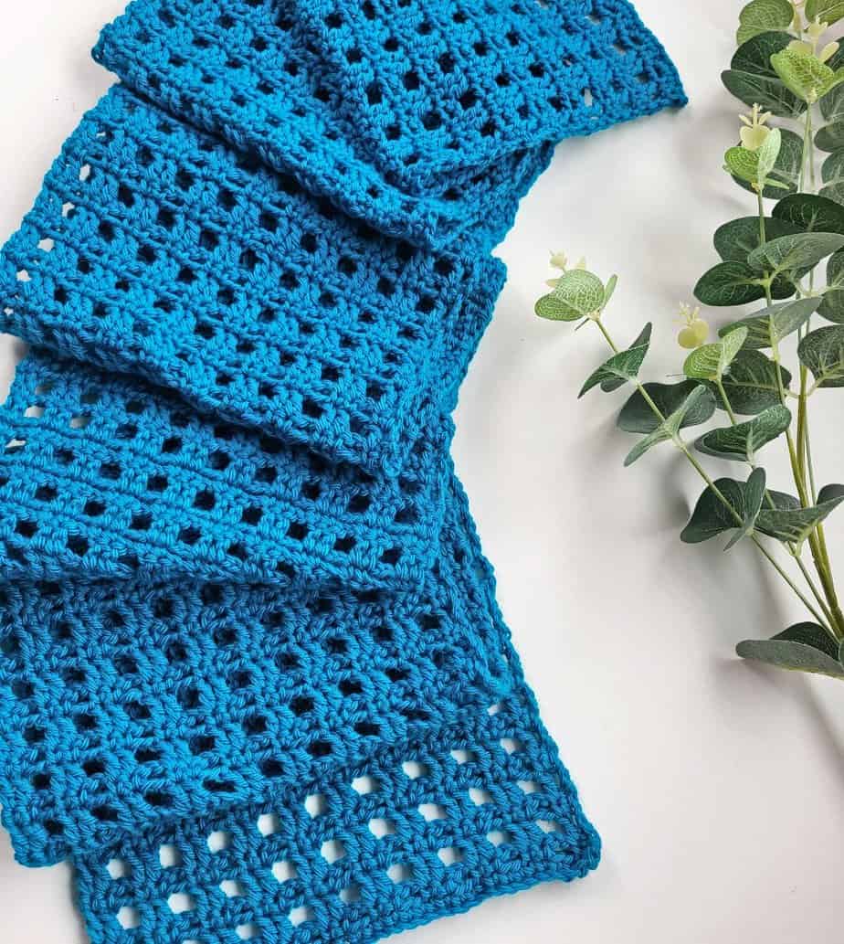 blue crochet scarf laid out on a table