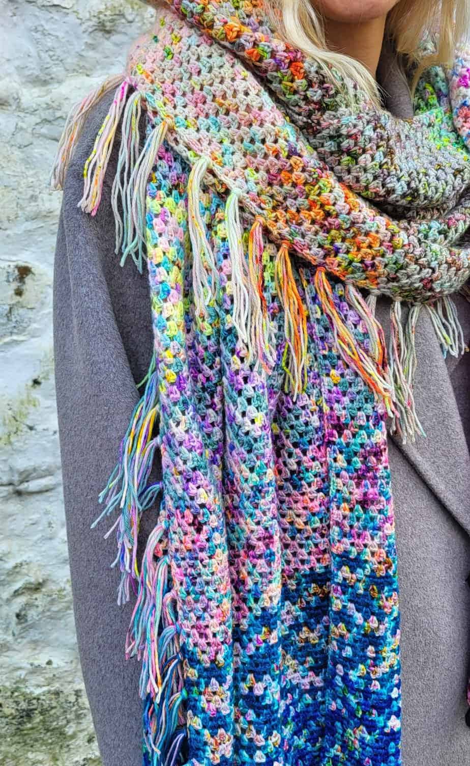 crochet shawl with a small fringe worn against a grey coat