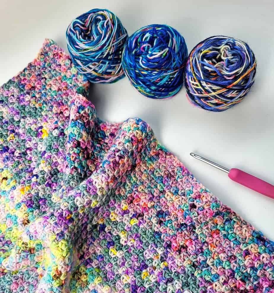 crochet linen stitch sample and 2 small skeins of blue yarn on a white background