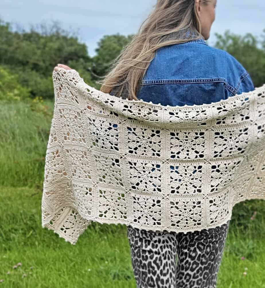 woman holding the Florette Crochet Flower Shawl out to show the design