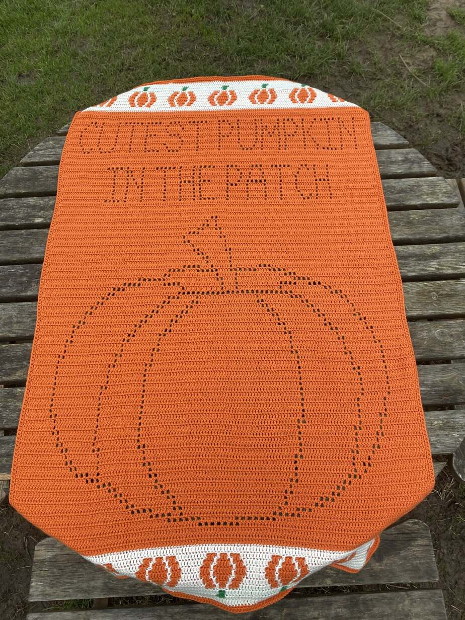 orange crochet blanket with pumpkin design