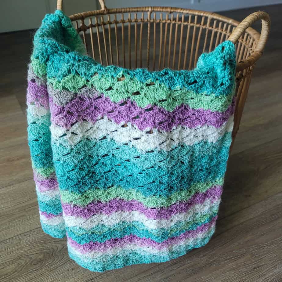 crochet blanket on a basket in self striping yarn