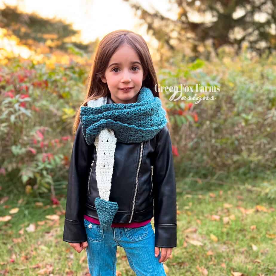 girl wearing a dragon tail crochet scarf