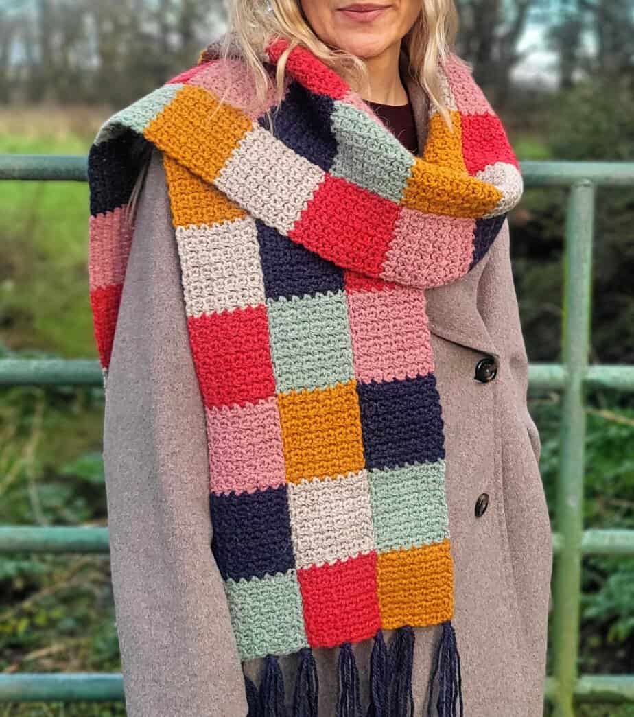 A woman wearing the bramley scarf wrapped loosely around her shoulders
