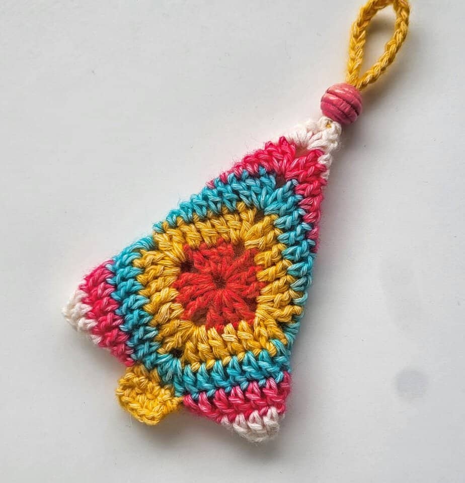 Colorful granny square Christmas tree ornament shown on a white background